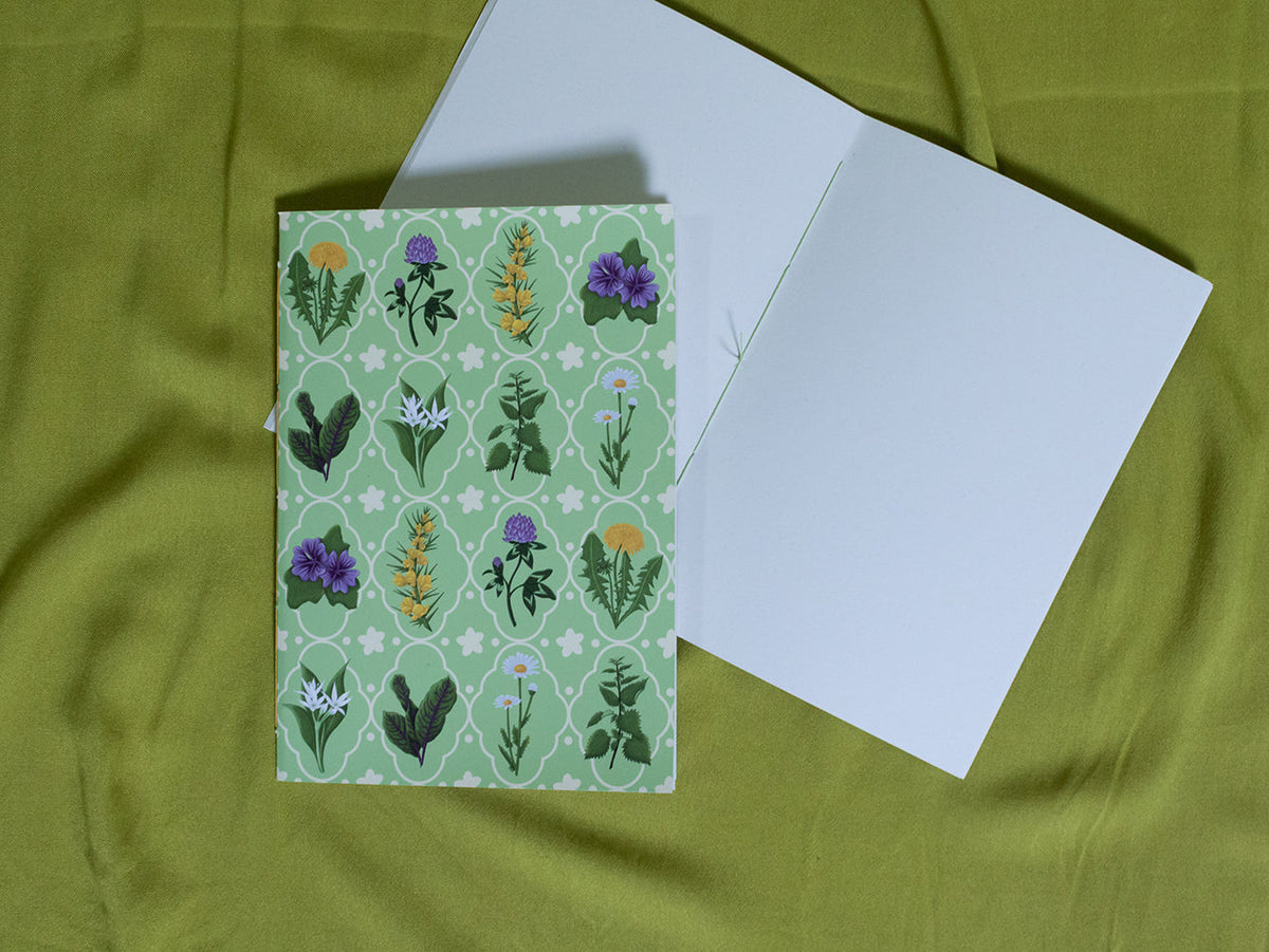 Sketchbook with floral pattern on green fabric