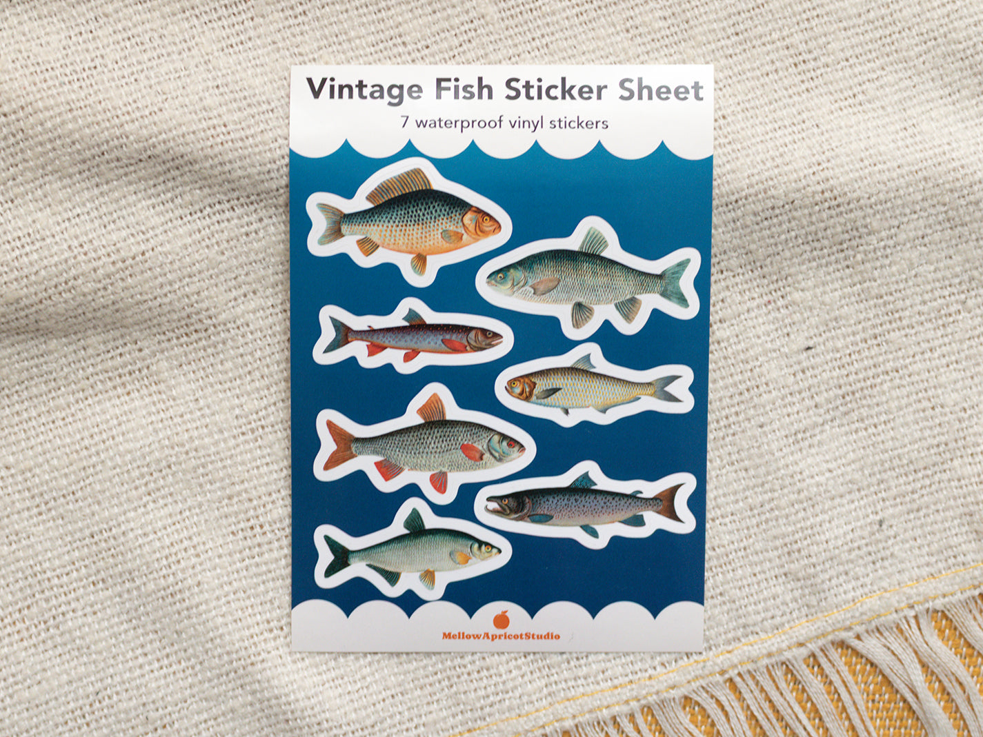 Vintage fish sticker sheet with illustrations on a textured fabric background