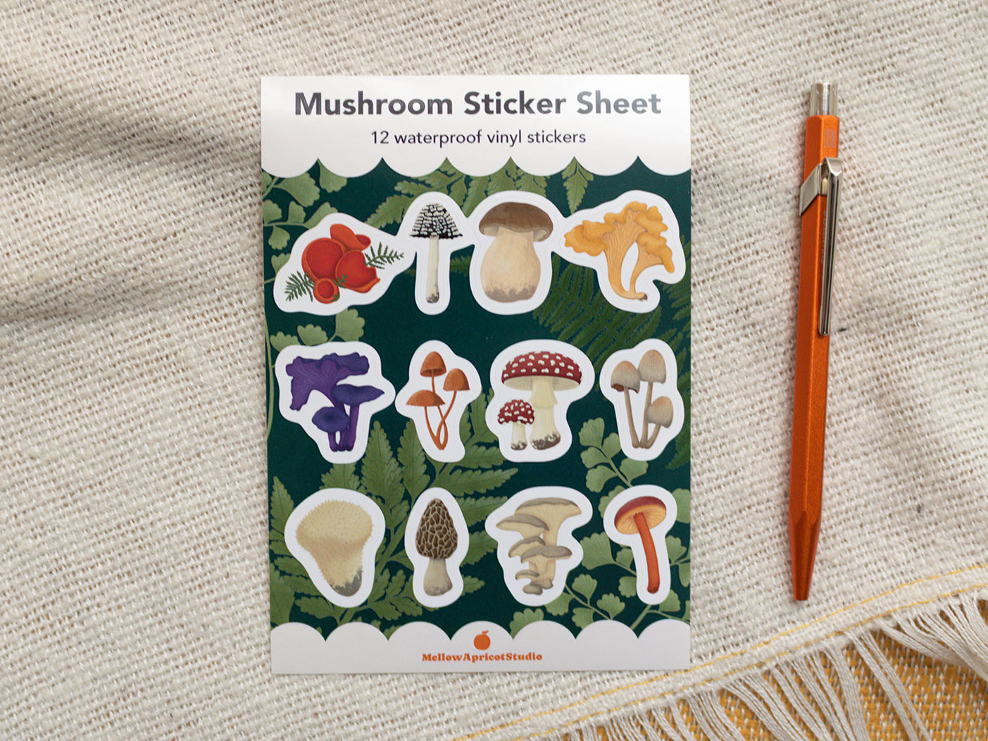 Mushroom sticker sheet with 12 waterproof vinyl stickers on a textured fabric background