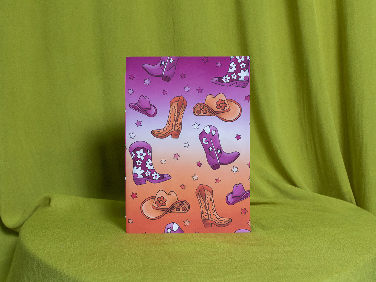 Sketchbook with cowboy boot and hat designs on a green background