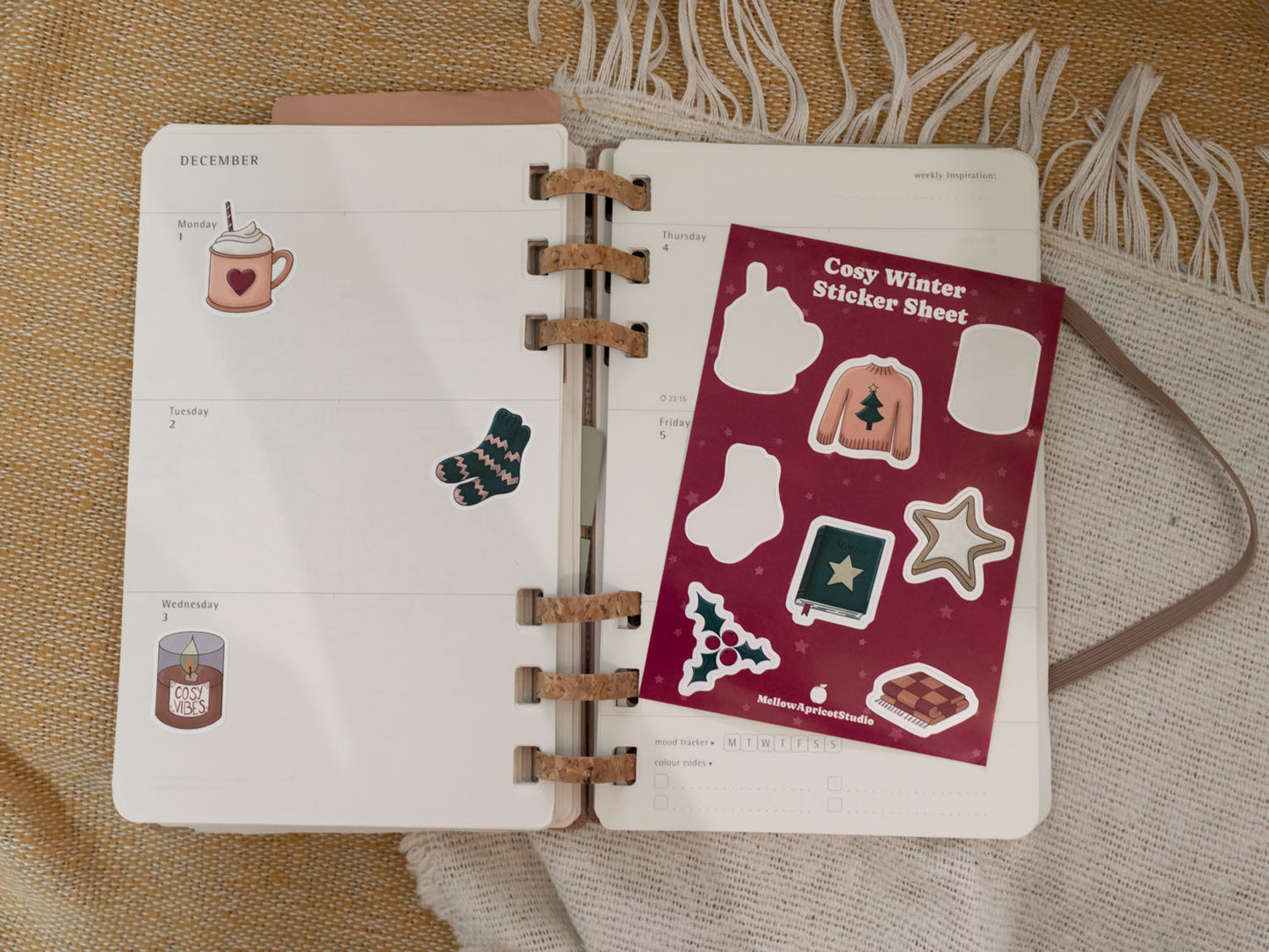 Open planner with cosy winter stickers on a textured surface