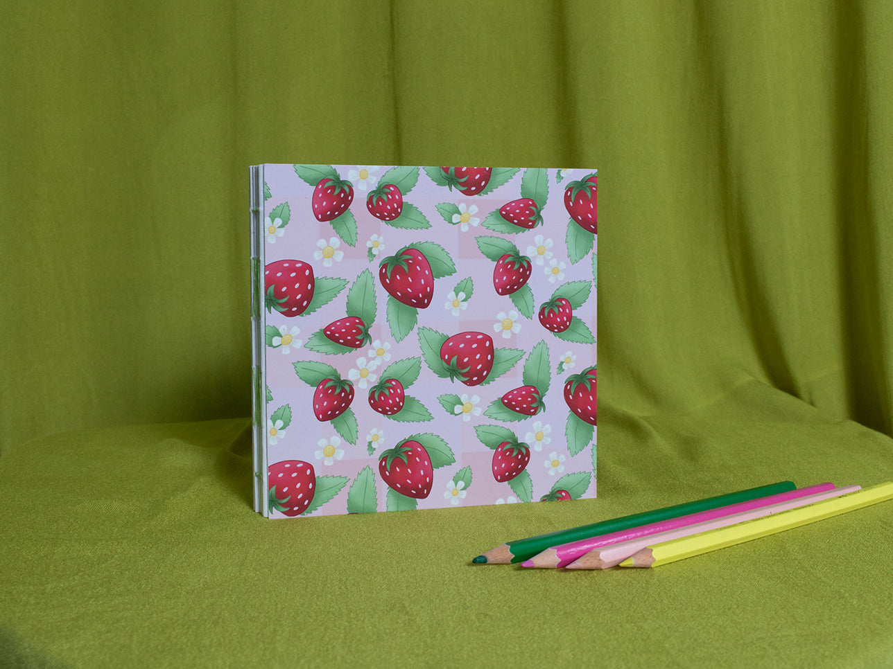 Square sketchbook with strawberry pattern on a green background
